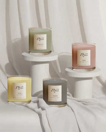 Ziya soy wax candles elegantly arranged on white pedestals against a soft, neutral fabric backdrop. A minimalist and sophisticated display, perfect for gifting.