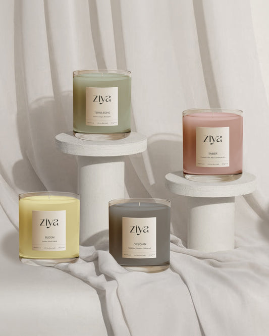 Ziya soy wax candles elegantly arranged on white pedestals against a soft, neutral fabric backdrop. A minimalist and sophisticated display, perfect for gifting.